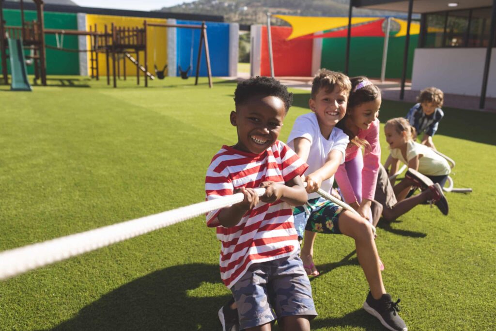 Group of school kids playing tug of war